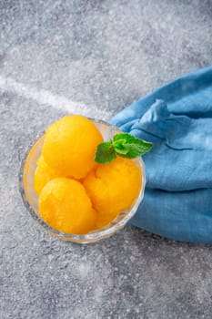 Mango sorbet scoop in the glass bowl