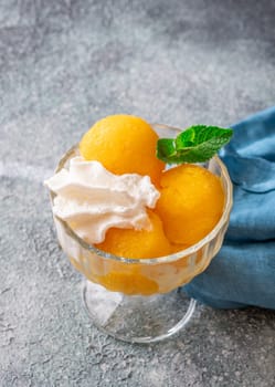 Mango sorbet scoop in the glass bowl