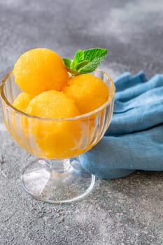 Mango sorbet scoop in the glass bowl