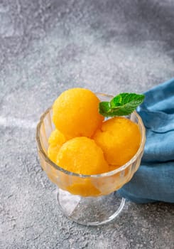 Mango sorbet scoop in the glass bowl