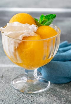Mango sorbet scoop in the glass bowl