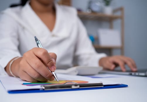 Business woman people use computers and paper documents to analyze business and manage corporate information. Business analysis with charts, indicators, and KPIs to improve organizational performance.