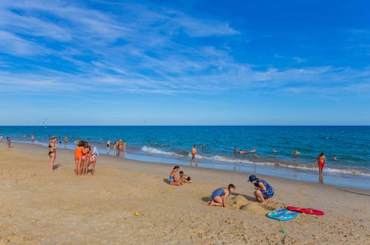 Tavira, Portugal - August 15, 2023: People at the famous beach of Tavira island in Tavira. This beach is a part of famous tourist region of Algarve.