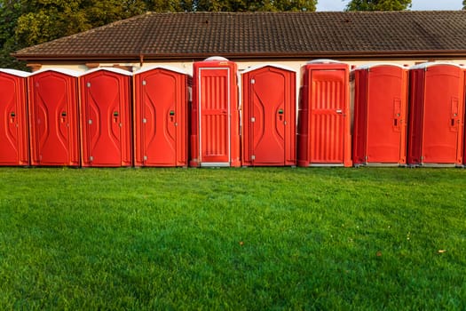 Portable plastic red toilets in a park - mobile sanitary system