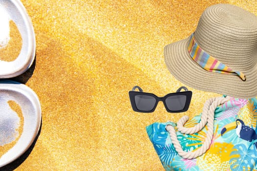 Womens beach accessories. Straw hat and beach bag, Flip-Flops or beach, sandales, sunglasses on a golden sunny sandy beach. Advertisment travel. Space.