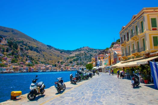 SYMI, Greece - Jun 03, 2021. The harbour of Symi town with the districts of Chorio and Gialos is one of the most beautiful and romantic in the whole Aegean. Colourful mansions stretch up the steep slopes.