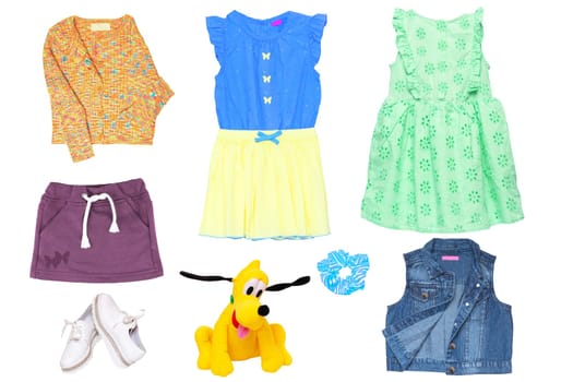Collage set of little girl summer clothes isolated on white. Kids apparel collection. Childs fashion clothing outfit. Skirt, shorts, shirt, dresses, jeans jacket, funny toy, sweater, shoes.