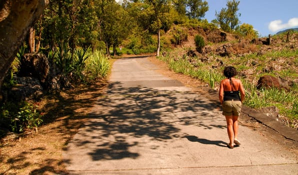 a woman walks on a small road on Reunion Island