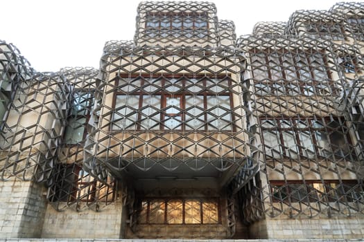 The facade of the National University Library of Kosovo, covered by a metal grid, net, an example of socialist, brutalist architecture in the city center of Prishtina, Pristina, Kosovo 2022