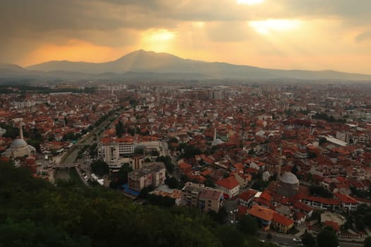 View from the Prizren Fortress onto the old town of Prizren before sunset, golden sunlight is breaking through the clouds, Prizren, Kosovo 2022