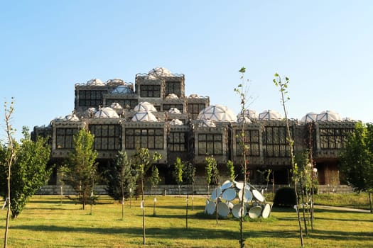 The the National University Library of Kosovo, covered by a metal grid, net, many white domes with geometric pattern on top, an example of socialist, brutalist architecture in the city center of Prishtina, Pristina, Kosovo 2022
