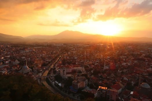 View from the Prizren Fortress onto the old town of Prizren, covered in golden sunlight during sunset, Prizren, Kosovo 2022