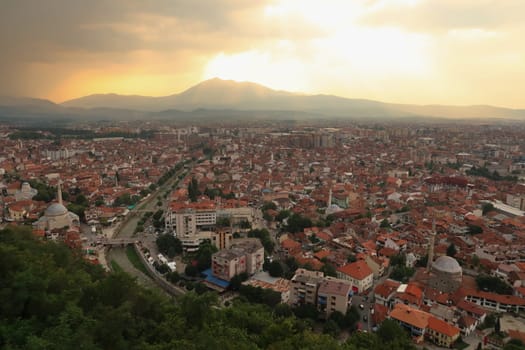 View from the Prizren Fortress onto the old town of Prizren before sunset, golden light is shining through the clouds, Prizren, Kosovo 2022
