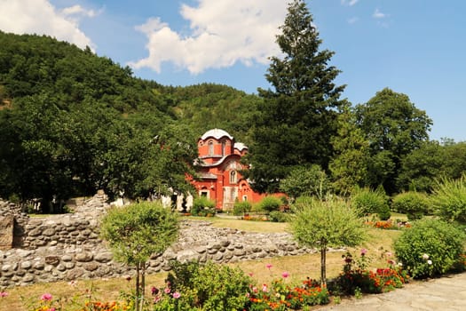 Inside the courtyard, garden of the Patriarchate of Pec Monastery, view between the trees onto the Church Complex, outside Peja, Kosovo 2022