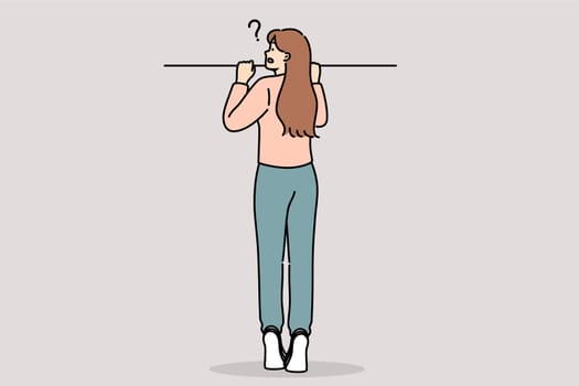 Curious woman peeks out from behind fence, standing on tiptoes to spy on neighbors. Curious girl does not understand what is happening and suffers due to lack of information that raises new questions.
