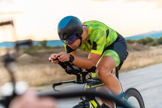 Triathlete riding his bicycle during sunset, preparing for a marathon. The warm colors of the sky provide a beautiful backdrop for his determined and focused effort