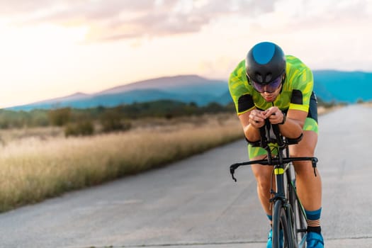Triathlete riding his bicycle during sunset, preparing for a marathon. The warm colors of the sky provide a beautiful backdrop for his determined and focused effort