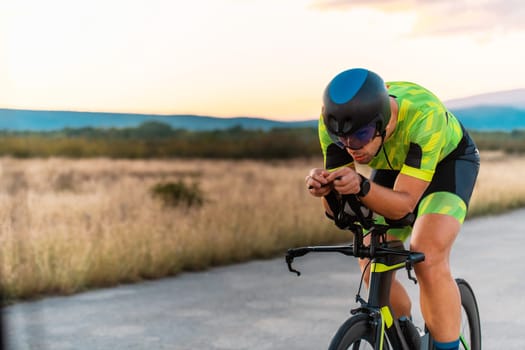Triathlete riding his bicycle during sunset, preparing for a marathon. The warm colors of the sky provide a beautiful backdrop for his determined and focused effort