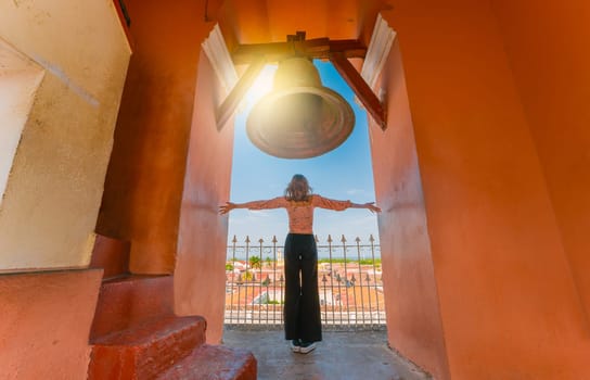 Tourists spreading arms at the viewpoint of the La Merced church with a view of the Granada cathedral. View of the bell