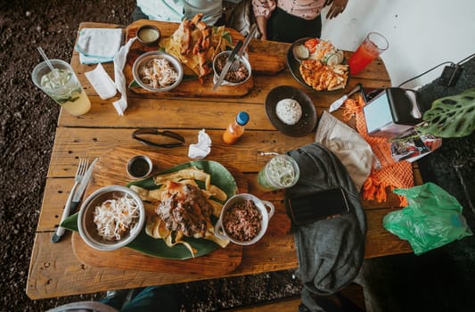 Top view of a table with traditional roast meats and gallopinto. Traditional roast beef with slices of banana and gallopinto served on a wooden table.