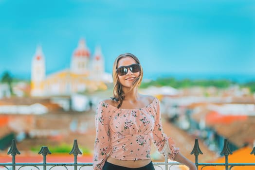 Happy young woman on vacation in Granada city, Nicaragua. Portrait of a beautiful tourist girl with a view of the cathedral in Granada