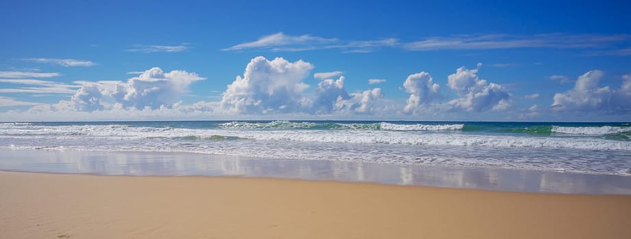 Panoramic view of Sky Clouds Surf and Sand Background on a sunny day at the beach