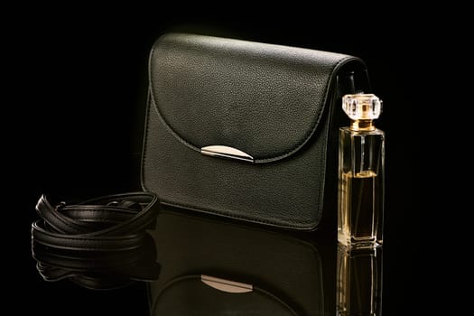 A black handbag stands on black glass. High quality photo