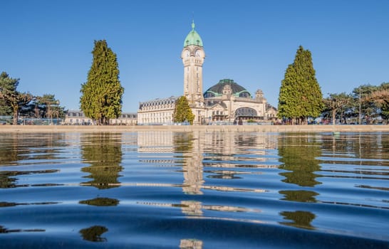 Limoges, France - April 04 2023: View of the famous Limoges train station called Limoges-Bénédictins reflecting in water, in France