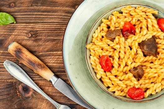 Tasty boiled and fried macaroni or pasta with beef and vegetables.