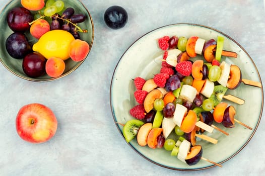 Fresh fruit skewers on sticks.
