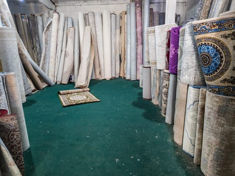 Many rolled carpets in Asian carpet store and carpet warehouse.