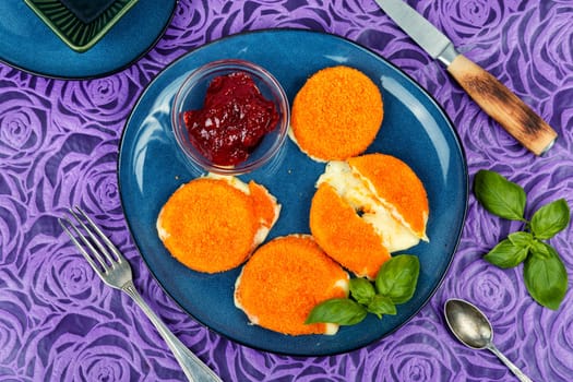 Baked and melted camembert cheese with berry sauce