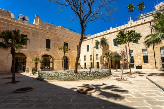 Historic Grandmaster's Palace courtyard with impressive architectural details and traditional Maltese stonework in Valletta. Cultural heritage of Malta