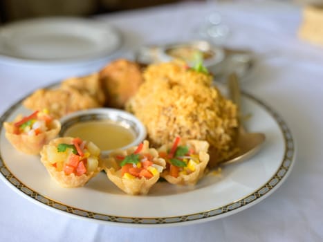 Minced Chicken and Sweet Corn in Crispy Golden Cup or Kratong Thong on white plate. Thai appitizer food