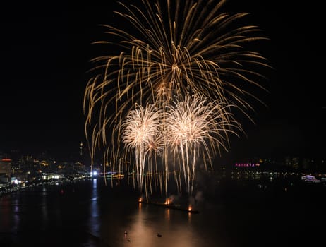 Big yellow firework on the sky at Pattaya coast with cityscape background, Thailand