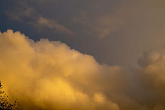 Big yellow cloud in the sky in the evening sun