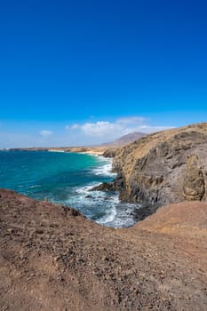 View of the Atlantic Ocean with its rocky cliffs and the beautiful Papagayo beaches on the Canary Island of Lanzarote in the Atlantic Ocean