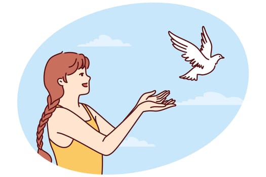Little girl volunteers teenager sets dove free and lets bird fly towards sky for family reunion. Dove symbolizes peace and prosperity or activism to protect animal birds locked in cages