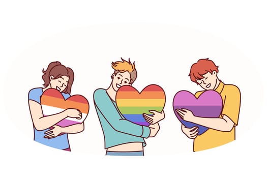 People hugging hearts painted in colors of LGBT and LGBTQ flags making freedom of choice in sex and lifestyle. concept of public tolerance for people from LGBT pride community or transgender people