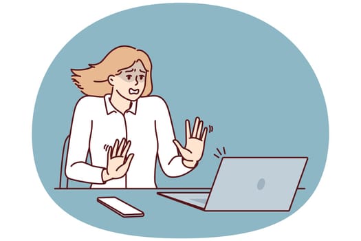 Frightened businesswoman sitting at table and looking at laptop after seeing cash gap notice in own company. Shocked businesswoman after error or notification about presence of viruses in computer