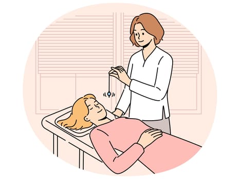 Psychiatrist hypnotizes female patient to treat psychological problems caused by difficult childhood. Girl lies on couch with eyes closed while undergoing hypnotizes therapy and arriving in trance