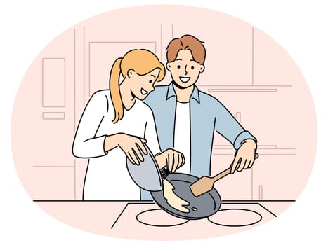 Married couple prepares breakfast enjoying sunday morning and experiencing happiness from communicating with loved one. Happy couple of man and woman cooking pancakes or omelet together