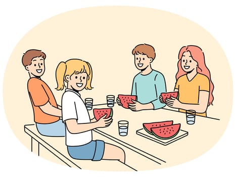 Children eat watermelon sitting at table and enjoying sweet refreshing dessert on hot summer day. Childrens picnic for boys and girls with delicious watermelon containing healthy vitamins