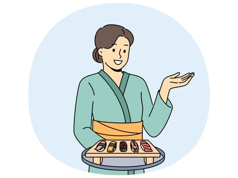 Woman sushi master with maki appetizer on wooden tray dressed in traditional asian kimono. Girl works in japanese food restaurant serving sushi from rice and fresh seafood to visitors.