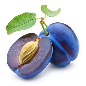 Fresh plums, one whole and one halved with seed visible, vibrant purple-blue skin, yellow interior, green leaf, isolated on white