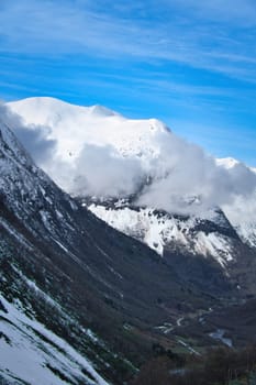 Norwegian landscape. The road leads through a mountain gorge that descends from the glacier. Rough nature in Scandinavia. Landscape photo from the north