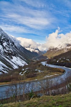 Norwegian landscape. The road leads through a mountain gorge that descends from the glacier. Rough nature in Scandinavia. Landscape photo from the north