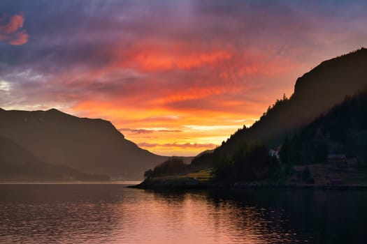 Norwegian fjord landscape with a view of the open sea at sunset. Water and mountains in the nature of Scandinavia