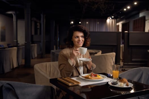 Pretty businesswoman eating lunch at hotel restaurant. Break time during business trip