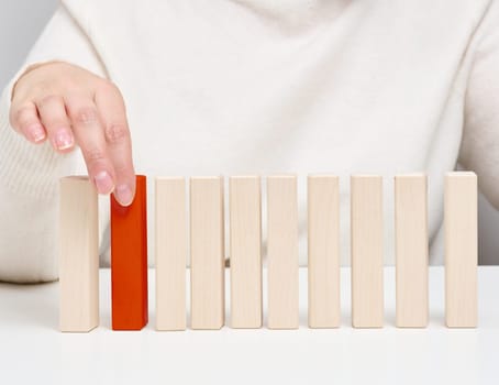 Wooden blocks on the table, a woman's hand holds one. The concept of finding unique, talented employees